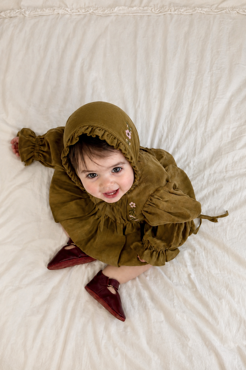 Baby wearing olive embroidered Florence bonnet