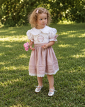 Girl in white and dusty pink embroidered linen dress