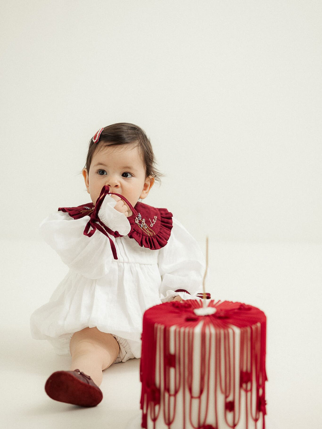 Baby wearing personalized white and burgundy embroidered romper