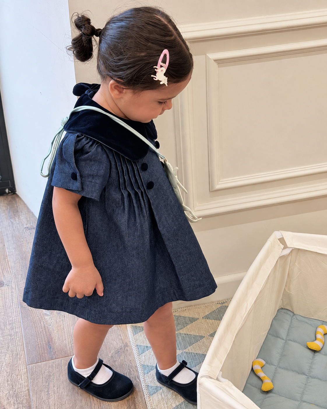 Girls navy-blue dress with soft dark collar photographed indoors
